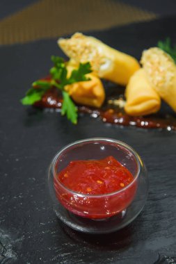 Hamurda et yuvarlanır. Et yemeği. Et ile rulo bir arka plan üzerinde bir cam Fincan Domates sosu.