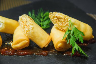 Hamurda et yuvarlanır. Et yemeği. Yeşillikile süslenmiş rulolar.