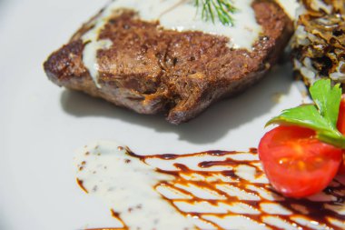 Krema soslu et kızartılır. Haşlanmış pirinç şeklinde süsler. Dereotu ile et biftek.