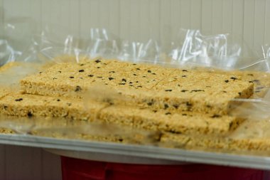 Kuru üzüm ile tatlı dilimlenmiş hamur. Şeker fabrikasında tatlı chak-chak pişirme. Hamur tatlı tatlı.