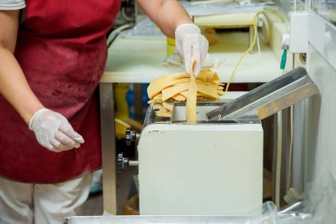 Hamuru dilimleme aleti. Şeker fabrikasında tatlı chak-chak pişirme. Hamur tatlı tatlı.