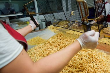 Şeker şurubu içinde pişirilen hamur örgü şeklinde dökülür. Şeker fabrikasında tatlı chak-chak pişirme. Hamur tatlı tatlı.