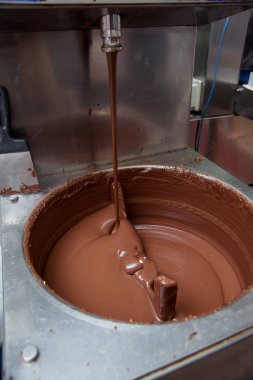 Şeker fabrikasında sütlü çikolata hazırlanması. Tatlı tatlı. Çikolata kütlesini karıştırmak için makine.