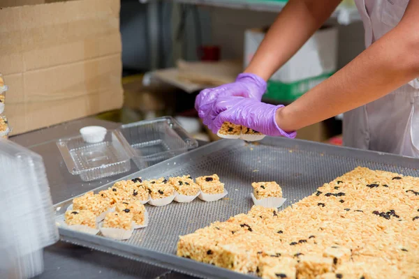 Packaging of dessert Chuck-Chuck on plastic containers. Preparation of pastries at the confectionery factory. Sweet dessert made of dough and honey.