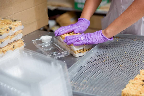 Packaging of dessert Chuck-Chuck on plastic containers. Preparation of pastries at the confectionery factory. Sweet dessert made of dough and honey.