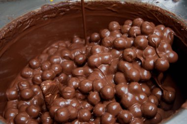 Fabrikada çikolata üretimi. Büyük bir metal fincan sütlü çikolata. Tatlı pasta.