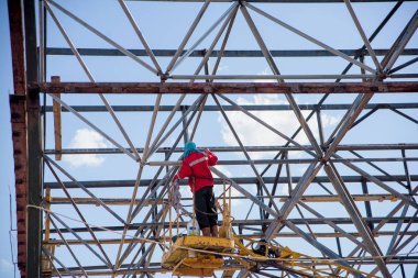 Vinçteki adam. Binadaki iskele. Metal çerçeve li bina.