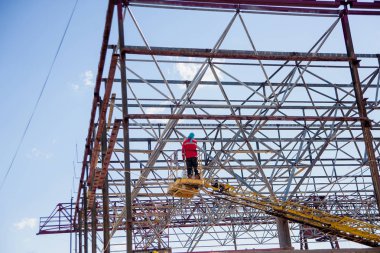 Vinçteki adam. Binadaki iskele. Metal çerçeve li bina.