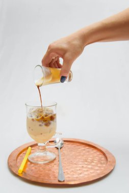 Soğuk kahve hazırlanması. Bir tepsi üzerinde bir alkolsüz içki duruyor. Americano buz üzerinde.