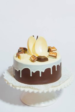 Yuvarlak bir rakam ile çikolatalı kek. Çikolata parçaları ile süslenmiş tatlı şekerleme. Çikolata buzlanma ile pasta stand üzerinde.