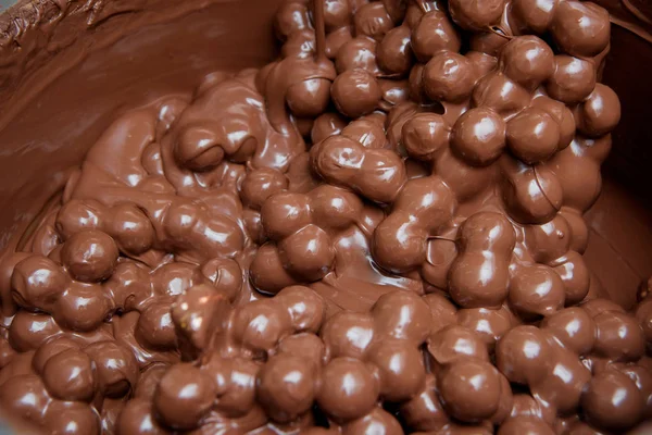 Production of chocolates in the factory. Milk chocolate in a large metal Cup. The sweet pastry.