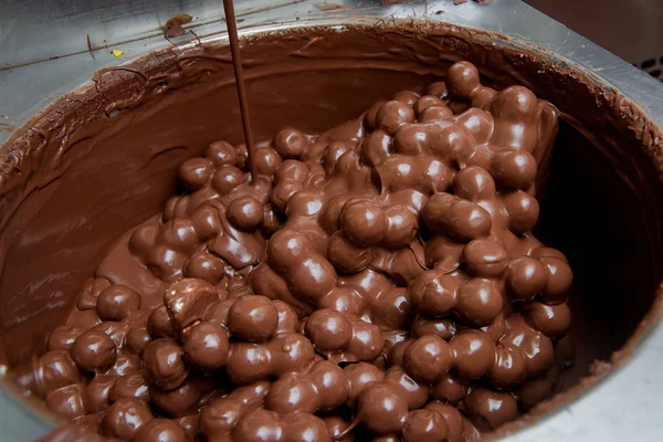 Production of chocolates in the factory. Milk chocolate in a large metal Cup. The sweet pastry.