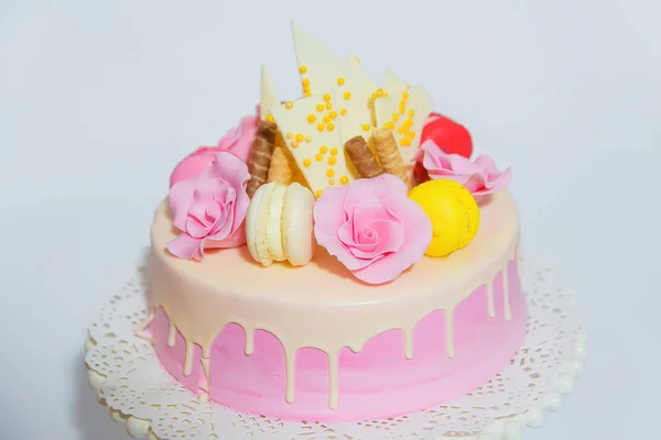 白色背景的粉红色蛋糕 用巧克力和彩色马卡龙蛋糕装饰在粉红色釉面上的甜糕点在展台上 — 图库照片