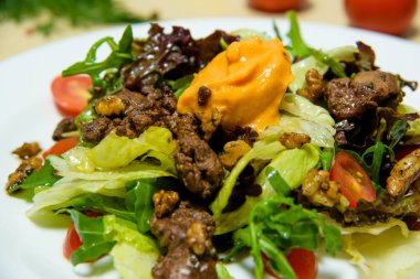 Roka ve kızarmış et ile salata. Peynir kiraz domates ve peynir sosu ile yeşil salata. Hafif bir masaya karşı bir tabak yiyecek.