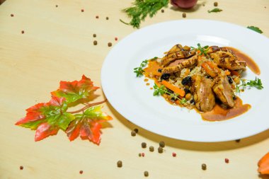 Sos eti ile haşlanmış pirinç. Kuru üzüm ve nohut. Hafif bir masaya karşı bir tabak yiyecek.