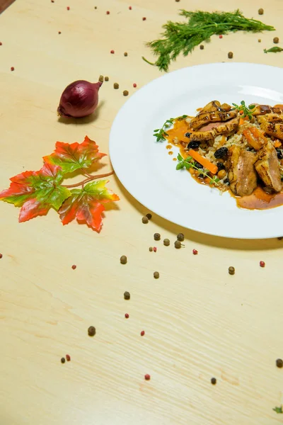 用酱汁煮的米饭 皮拉夫配葡萄干和鹰嘴豆 一盘靠在轻桌上的食物 — 图库照片