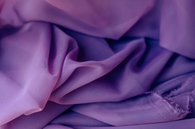 Mor kumaş. Mor malzemenin yüzeyinde kıvrımlar doku. Kumaşlı alışveriş.