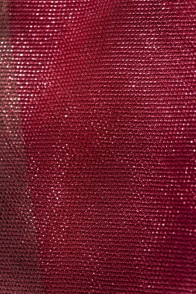 Fabric with pink sequins. The texture of the shiny material. Decorative fabric trimmed with pink sequins.