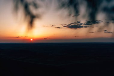 Gökyüzünde turuncu gün batımı. Kazygurt Dağı'nın manzarası. Kazakistan'ın Türkistan bölgesinde doğa.