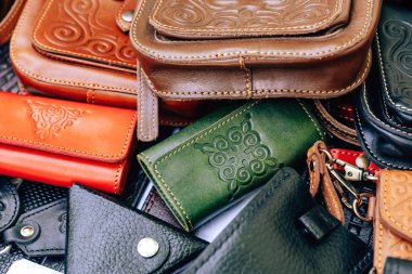 Ulusal Kazak süsü ile deri çanta ve çantalar. Kazakistan'da hakiki deriden yapılmış aksesuarlar. Çimkent şehrinde Arbat caddesi boyunca yürüyün.