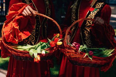 Kazak milli kızlarınla lale sepetleri tutuyorlar. Çimkent şehrinde Arbat caddesi boyunca yürüyün. Kazakistan'da çiçek festivali.