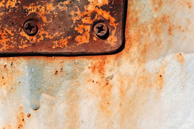 Kapıda eski demir plaka. Metal üzerinde korozyon. Metal ve ahşap doku. Demir cıvatalı vidalar