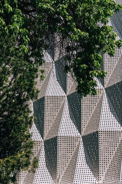 Metal facade of the building. Texture of embossed metal surface with holes. Walk along Arbat street in the city of Shymkent.