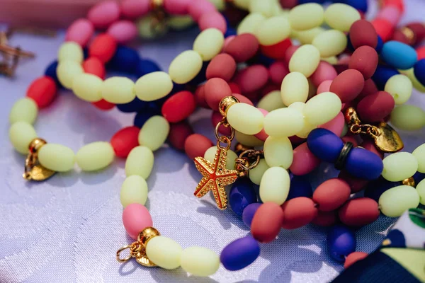 Bracelets of colored stones. Hand maid jewelry. Walk along Arbat street in the city of Shymkent. Festival of flowers in Kazakhstan.