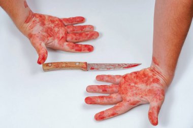 Elinde beyaz bir arka plan üzerinde keskin bir bıçak olan bir adam. Hafif bir arka plan üzerinde kanlı eller. Tehlikeli yakın dövüş silahları bir insanın kanlı elinde. Mutfak bıçağının dikkatsiz kullanımı. Kan bıçağı
