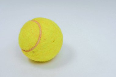 Tenis için sarı top. Beyaz arka planda yuvarlak limon rengi top. Elastik tenis topu