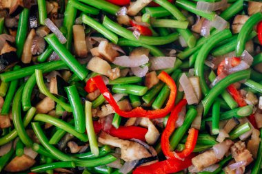 Bir tavada taze sebze doku. Sarımsak tüpleri ve biber ile kızarmış patlıcan. Düşük kalorili öğle yemeği