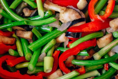 Bir tavada taze sebze doku. Sarımsak tüpleri ve biber ile kızarmış patlıcan. Düşük kalorili öğle yemeği