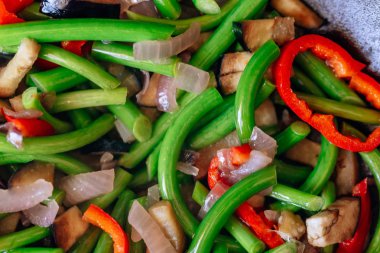 Bir tavada taze sebze doku. Sarımsak tüpleri ve biber ile kızarmış patlıcan. Düşük kalorili öğle yemeği