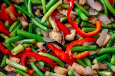 Bir tavada taze sebze doku. Sarımsak tüpleri ve biber ile kızarmış patlıcan. Düşük kalorili öğle yemeği