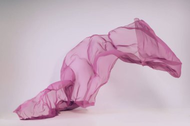 Beyaz arka plan üzerine mor kumaş. Fotoğraf stüdyosunda ultraviyole doku levitation. Yükselen bir pamuklu kumaş parçası. Açık bir arka plan üzerinde uçan renkli kumaş