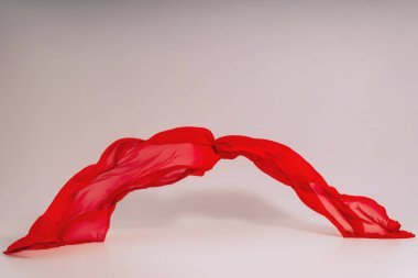 Beyaz arka plan üzerinde kırmızı kumaş. Fotoğraf stüdyosunda kırmızı kumaş Levitation. Pamuklu kumaş yükselen parçası. Açık bir arka plan üzerinde uçan renkli kumaş