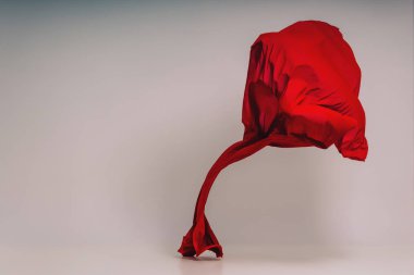 Beyaz arka plan üzerinde kırmızı kumaş. Fotoğraf stüdyosunda kırmızı kumaş Levitation. Pamuklu kumaş yükselen parçası. Açık bir arka plan üzerinde uçan renkli kumaş