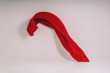 Beyaz arka plan üzerinde kırmızı kumaş. Fotoğraf stüdyosunda kırmızı kumaş Levitation. Pamuklu kumaş yükselen parçası. Açık bir arka plan üzerinde uçan renkli kumaş