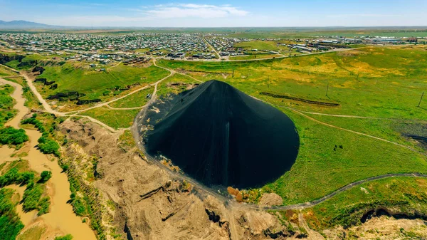 Panorama of the industrial part of the city of Shymkent. Black Mountain waste on the outskirts of the city. Lead slag next to the residents\' houses. Poisoning the river and land factory waste