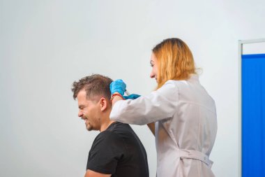 Doktorun ofisindeki kanepedeki adam. Genç bir adam için mezoterapi. Kafasına şırınga yla iğneler. Saç uzatma kel adam. Fotoğraf stüdyosundaki tıp ofisi. Vitamin enjeksiyonları