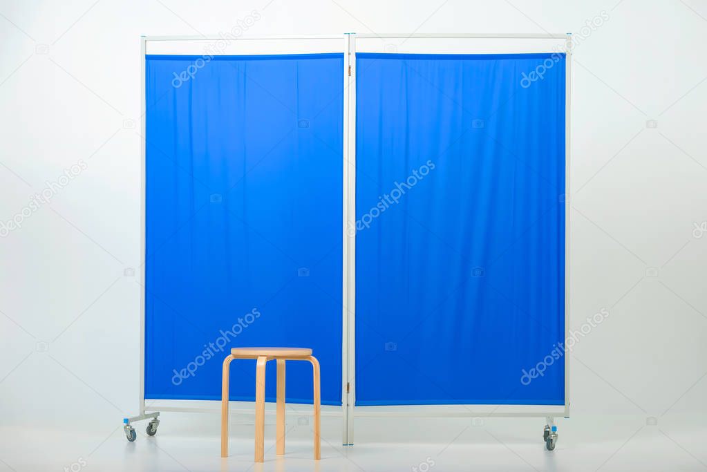 Chair against the blue medical screen. Procedures in the medical office. Reception in the doctor's office.