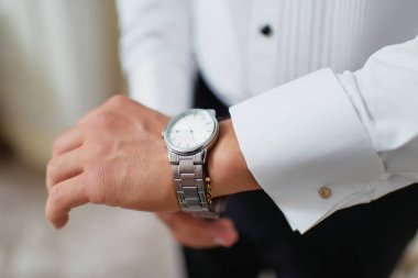 Damadın elindeki kol saatlerini giydirmek. Düğün hazırlıkları. Kazakistan'da Kazak düğünü. Düğün Damat