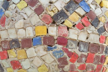 Duvarda renkli tuğlalar var. Çitte alışılmadık mozaik. Dekore güçlendirilmiş çit