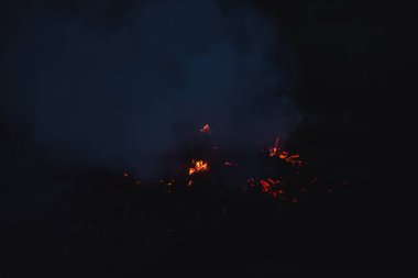 Şafakta nesli tükenmiş bir yangın. Alevler ve duman. Yangında kızgın kömürler. Kazakistan'da açık hava rekreasyon.