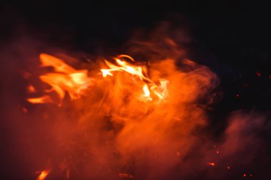 Geceleri yanan ateş. Büyük turuncu alev ve duman. Alevler içinde kırmızı-sıcak kömürler. Kazakistan'da açık hava rekreasyon.