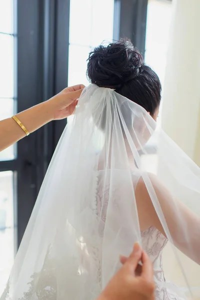 Dressing the wedding veil on the head of the bride. White veil at the Kazakh wedding. National Kazakh Wedding