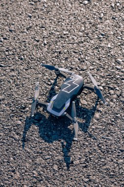 Asfalta yıldırım şeklinde bir çıkartma yapıştırılmış bir dron. Drone yolda etkisiz hale getirildi. Küçük siyah drone