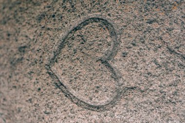 Bir taşa oyulmuş kalp işareti. Granitte aşk işareti. Taş gravür