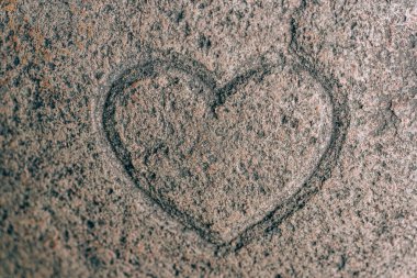 Bir taşa oyulmuş kalp işareti. Granitte aşk işareti. Taş gravür
