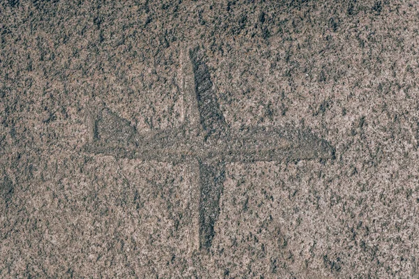 Airplane sign carved on the stone. Silhouette of an airplane on granite. Stone engraving